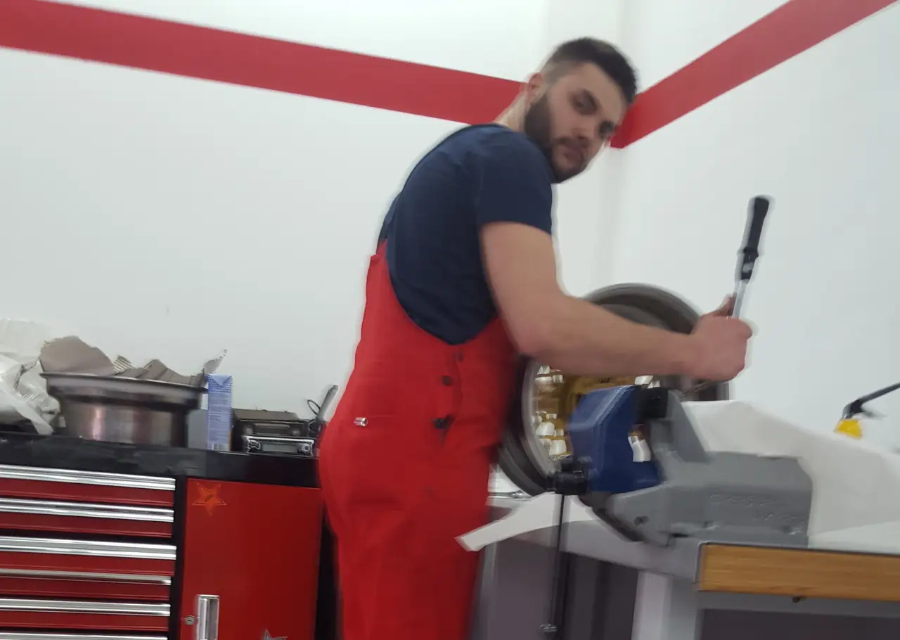 Mario Dellsperger in roter Werkstattkleidung bei der Arbeit an einer Felge