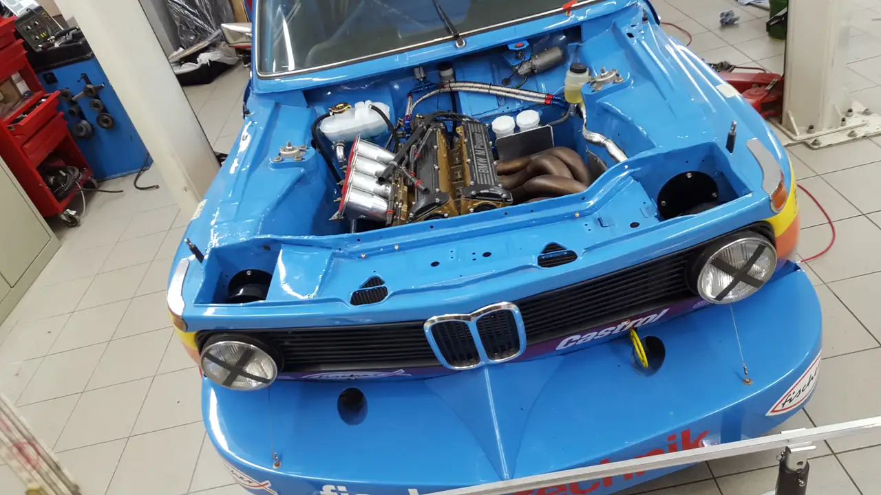 Rennumgebauter BMW mit offenem Motorraum in der Werkstatt